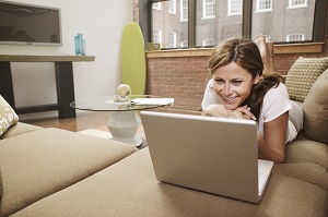 girl laying on couch on laptop